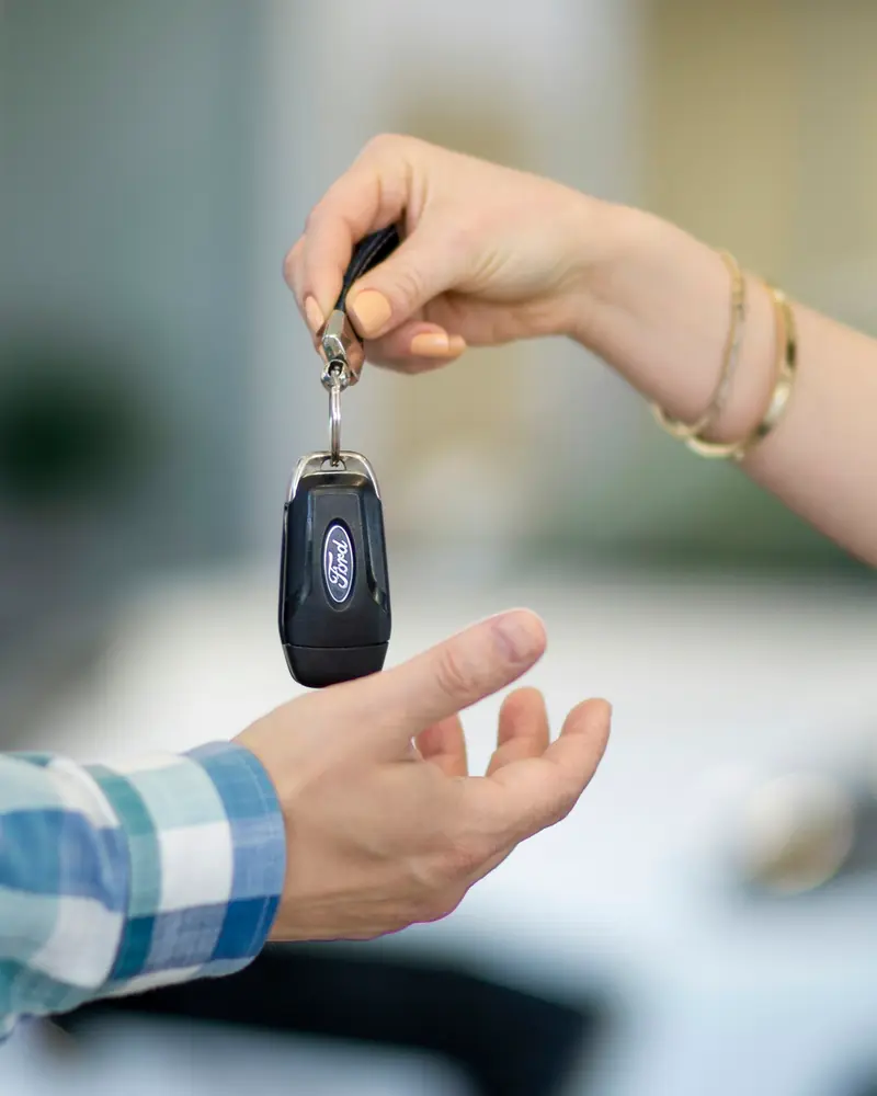 One hand passing a car key into another