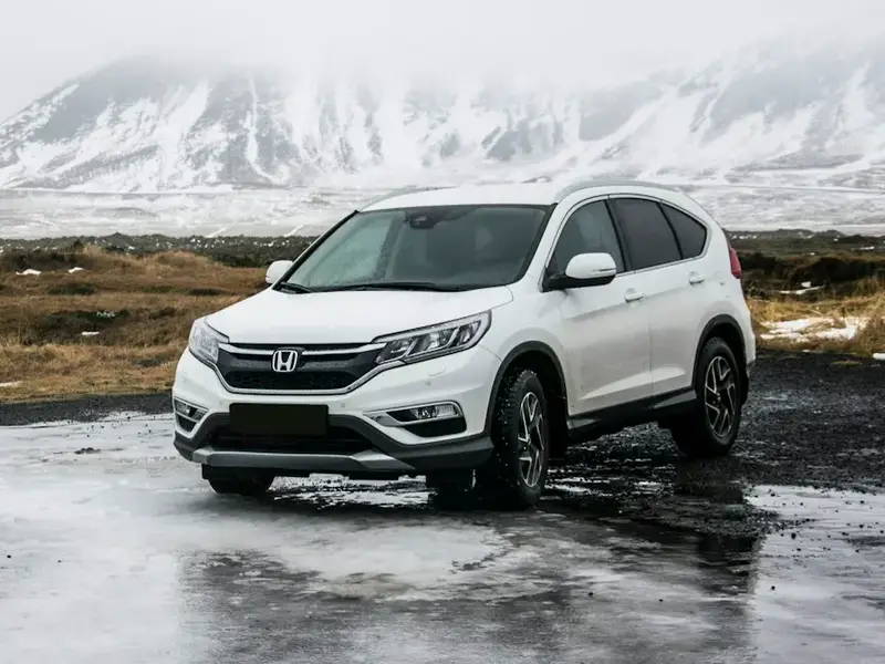 White Honda CR-V parked on a wet road